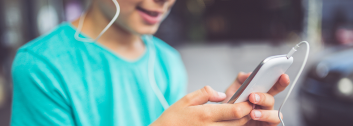 Young person wearing headphones and looking at mobile phone