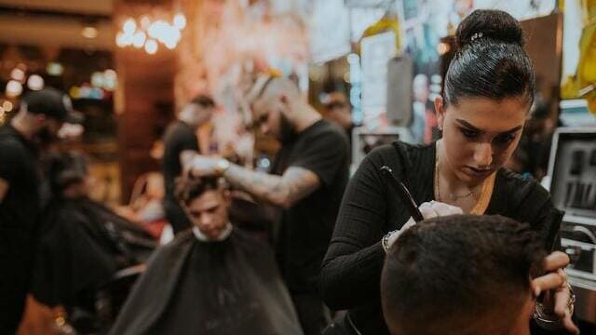 Hair and beauty apprentices cutting hair in barbers