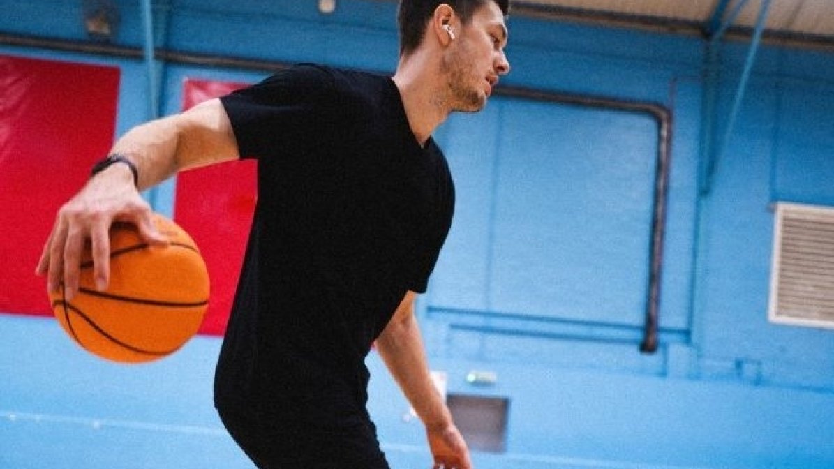 International student playing sport in uni gym