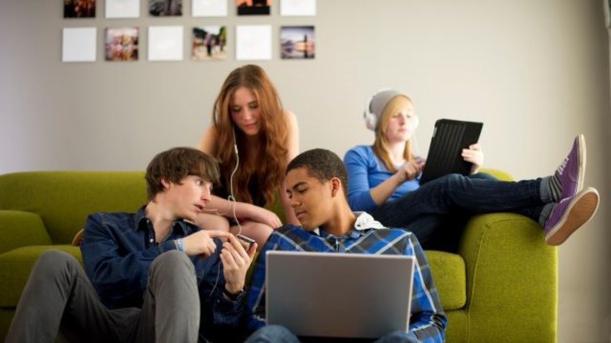 Students in accommodation using tablets and listening to podcasts