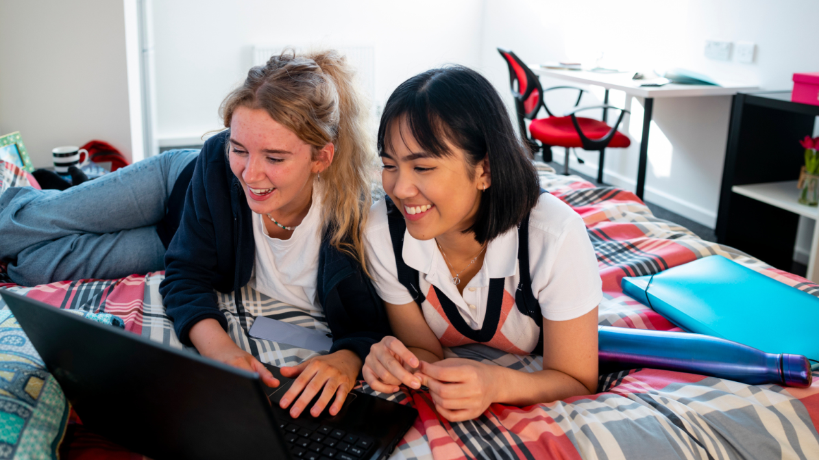 web-accommodation-image-box-5-2048-1361-080824.png Two students laid on a bed, looking at a laptop