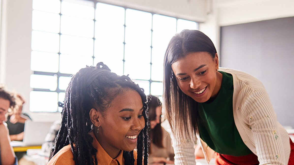 Adviser helping student in classroom