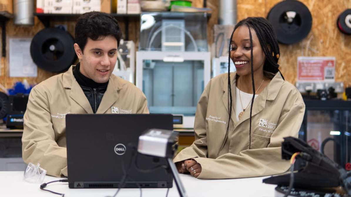 Apprentices working on laptop in a workshop 
