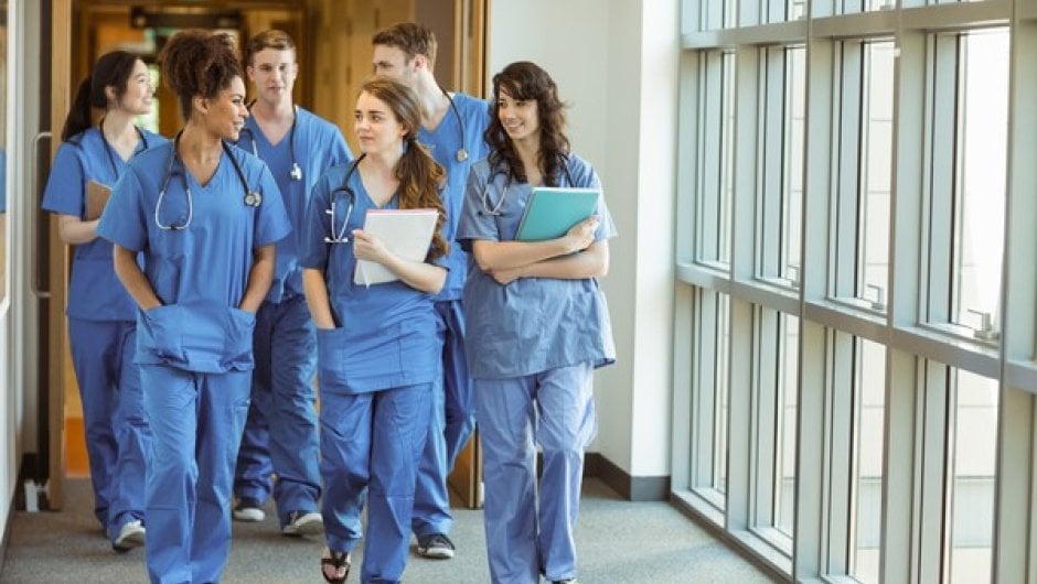 Trainee doctors walking in hospital corridor