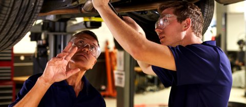 Apprentice mechanic working on a car