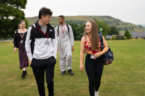 Industry_Marketing_Early_Careers_Article_Apprenticeships_Image_Box_7 A group of four students, laughing and chatting, walking across a school sports field